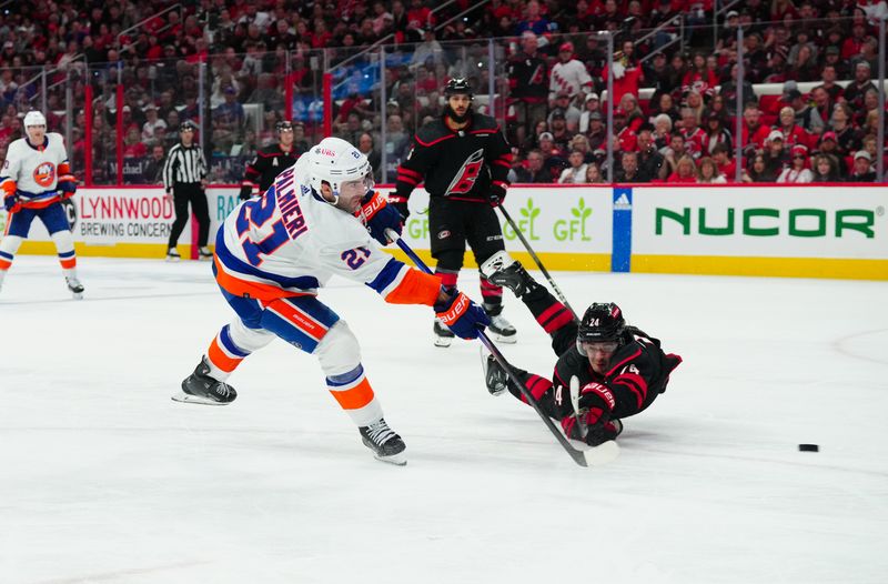 Apr 20, 2024; Raleigh, North Carolina, USA; New York Islanders center Kyle Palmieri (21) gets the shot past Carolina Hurricanes center Seth Jarvis (24) during the second period in game one of the first round of the 2024 Stanley Cup Playoffs at PNC Arena. Mandatory Credit: James Guillory-USA TODAY Sports