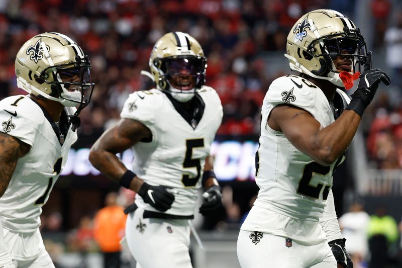 New Orleans Saints cornerback Paulson Adebo, right, celebrates his interception against the Atlanta Falcons during the first half of an NFL football game, Sunday, Sept. 29, 2024, in Atlanta. (AP Photo/Butch Dill)