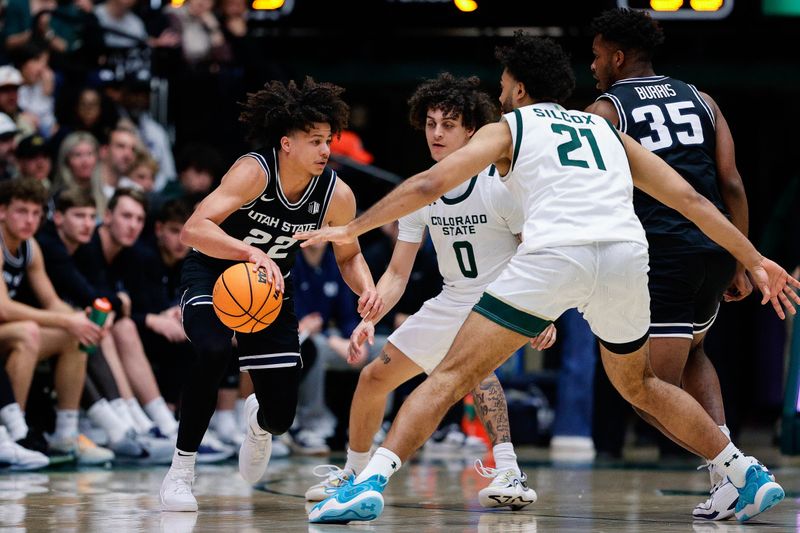 Feb 17, 2024; Fort Collins, Colorado, USA; Utah State Aggies guard Javon Jackson (22) controls the ball against Colorado State Rams guard Kyan Evans (0) and guard Rashaan Mbemba (21) as forward Nigel Burris (35) defends in the second half at Moby Arena. Mandatory Credit: Isaiah J. Downing-USA TODAY Sports