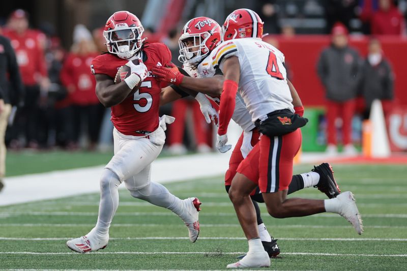 Nov 25, 2023; Piscataway, New Jersey, USA; Rutgers Scarlet Knights running back Kyle Monangai (5) fights for yards after the game Maryland Terrapins defensive back Tarheeb Still (4) and linebacker Fa'Najae Gotay (9) during the first half at SHI Stadium. Mandatory Credit: Vincent Carchietta-USA TODAY Sports