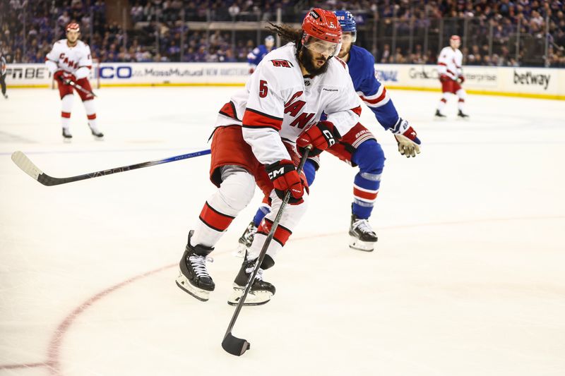 May 5, 2024; New York, New York, USA; Carolina Hurricanes defenseman Jalen Chatfield (5) controls the puck in the second period against the New York Rangers in game one of the second round of the 2024 Stanley Cup Playoffs at Madison Square Garden. Mandatory Credit: Wendell Cruz-USA TODAY Sports