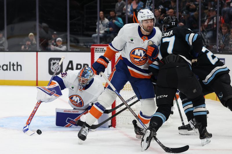Nov 14, 2025; Salt Lake City, Utah, USA; New York Islanders goaltender David Rittich (33) uses his stick to pull in the puck as defenseman Adam Pelech (3) pushes Utah Mammoth right wing JJ Peterka (77) away during the first period at Delta Center. Mandatory Credit: Rob Gray-Imagn Images