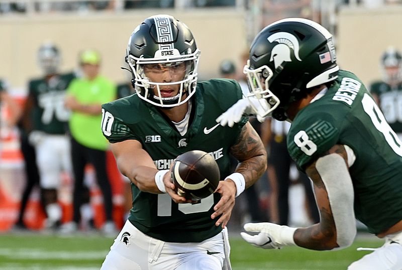 Sep 1, 2023; East Lansing, Michigan, USA;  Michigan State Spartans quarterback Noah Kim (10) hands the ball to Michigan State Spartans running back Jalen Berger (8) against the Central Michigan Chippewas at Spartan Stadium. Mandatory Credit: Dale Young-USA TODAY Sports