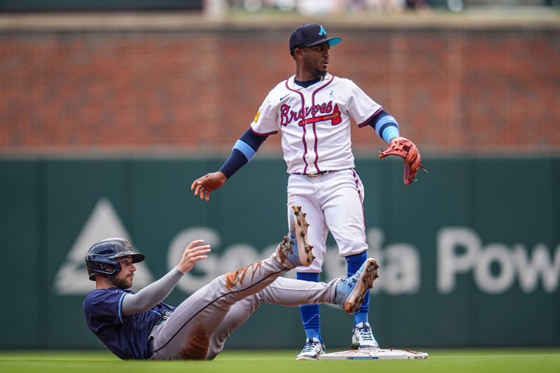 Jun 16, 2024; Cumberland, Georgia, USA; Tampa Bay Rays second baseman Brandon Lowe (8) tumbles after being forced out by Atlanta Braves second baseman Ozzie Albies (1) during a double play during the first inning at Truist Park. Mandatory Credit: Dale Zanine-USA TODAY Sports