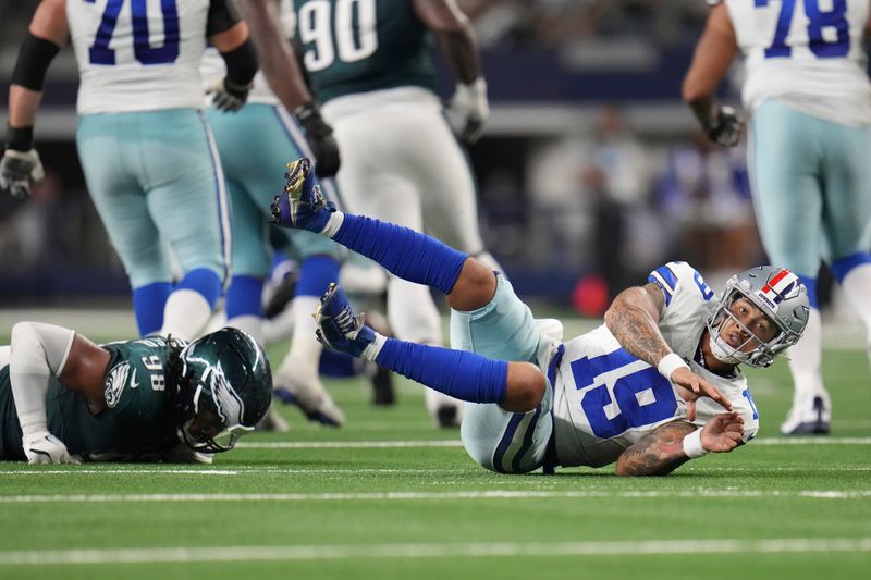 Dallas Cowboys quarterback Trey Lance (19) is knocked down by Philadelphia Eagles defensive tackle Jalen Carter (98) after throwing a completion in the second half of an NFL football game in Arlington, Texas, Sunday, Nov. 10, 2024. (AP Photo/Julio Cortez)