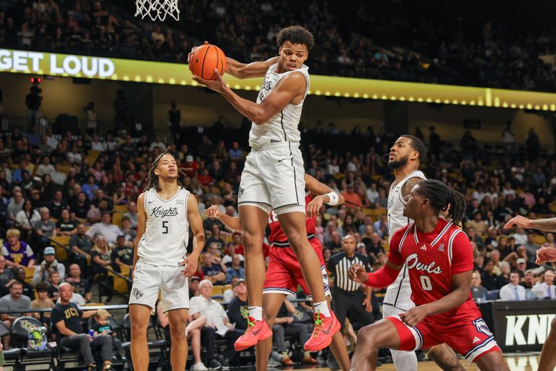 Nov 12, 2024; Orlando, Florida, USA; UCF Knights guard Keyshawn Hall (4) grabs a rebound during the first half against the Florida Atlantic Owls at Addition Financial Arena. Mandatory Credit: Mike Watters-Imagn Images