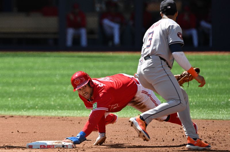 Jul 1, 2024; Toronto, Ontario, CAN; Toronto Blue Jays right fielder George Springer (4) steals second base ahead of a tag from Houston Astros shortstop Jeremy Pena (3) in the second inning at Rogers Centre. Mandatory Credit: Dan Hamilton-USA TODAY Sports