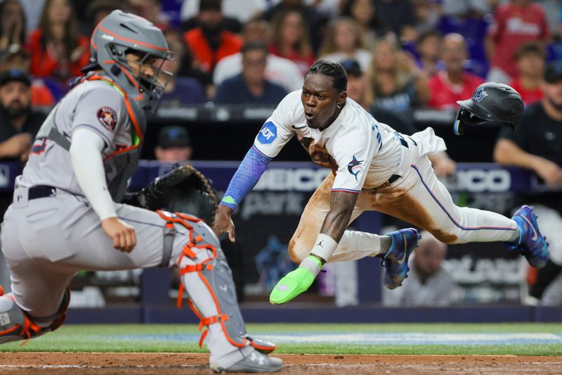 Aug 15, 2023; Miami, Florida, USA; Miami Marlins center fielder Jazz Chisholm Jr. (2) dives at home plate and scores against the Houston Astros during the fourth inning at loanDepot Park. Mandatory Credit: Sam Navarro-USA TODAY Sports