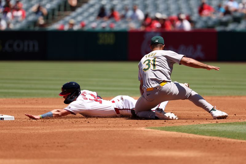 Jul 28, 2024; Anaheim, California, USA;  Los Angeles Angels catcher Logan O'Hoppe (14) is tagged out by Oakland Athletics second baseman Abraham Toro (31) on a caught stealing during the second inning at Angel Stadium. Mandatory Credit: Kiyoshi Mio-USA TODAY Sports