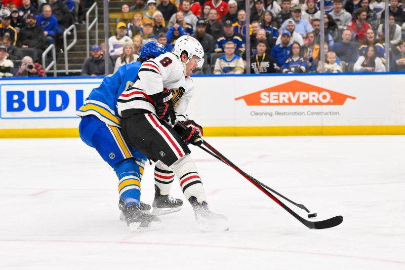 Mar 22, 2025; St. Louis, Missouri, USA;  Chicago Blackhawks center Ryan Donato (8) and St. Louis Blues defenseman Cam Fowler (17) battle for the puck during the third period at Enterprise Center. Mandatory Credit: Jeff Curry-Imagn Images