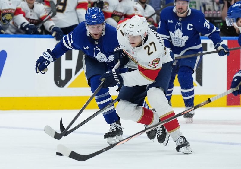 May 7, 2025; Toronto, Ontario, CAN; Florida Panthers center Eetu Luostarinen (27) skates with the puck as Toronto Maple Leafs defenseman Brandon Carlo (25) gives chase during the second period in game two of the second round of the 2025 Stanley Cup Playoffs at Scotiabank Arena. Mandatory Credit: Nick Turchiaro-Imagn Images