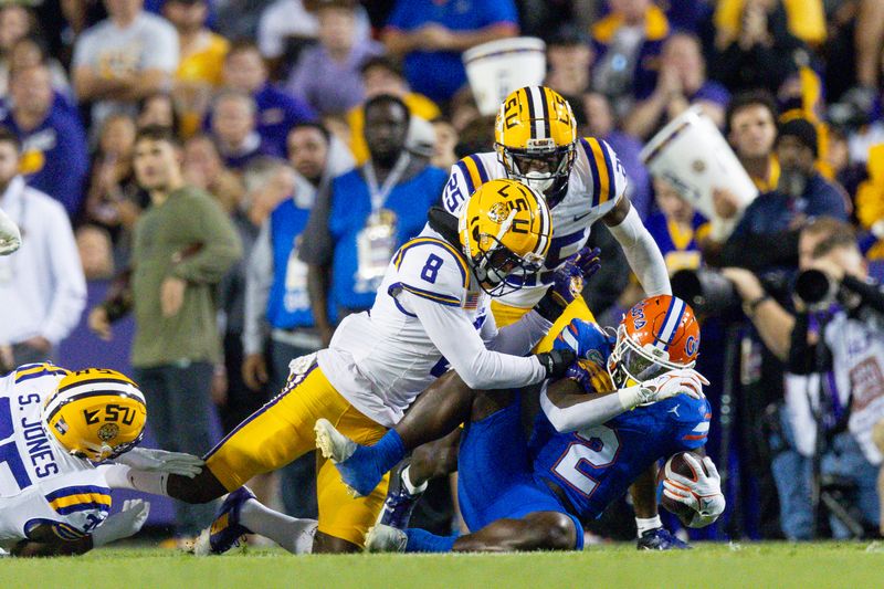 Nov 11, 2023; Baton Rouge, Louisiana, USA;  LSU Tigers safety Major Burns (8) tackles Florida Gators running back Montrell Johnson Jr. (2) during the first half at Tiger Stadium. Mandatory Credit: Stephen Lew-USA TODAY Sports