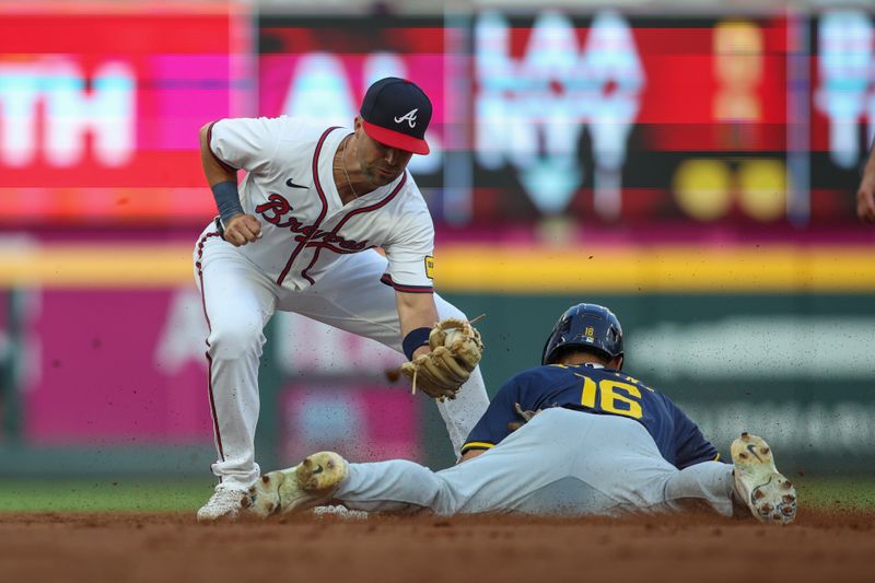 Aug 7, 2024; Atlanta, Georgia, USA; Milwaukee Brewers center fielder Blake Perkins (16) slides safely under the tag of Atlanta Braves second baseman Whit Merrifield (15) in the second inning at Truist Park. Mandatory Credit: Brett Davis-USA TODAY Sports