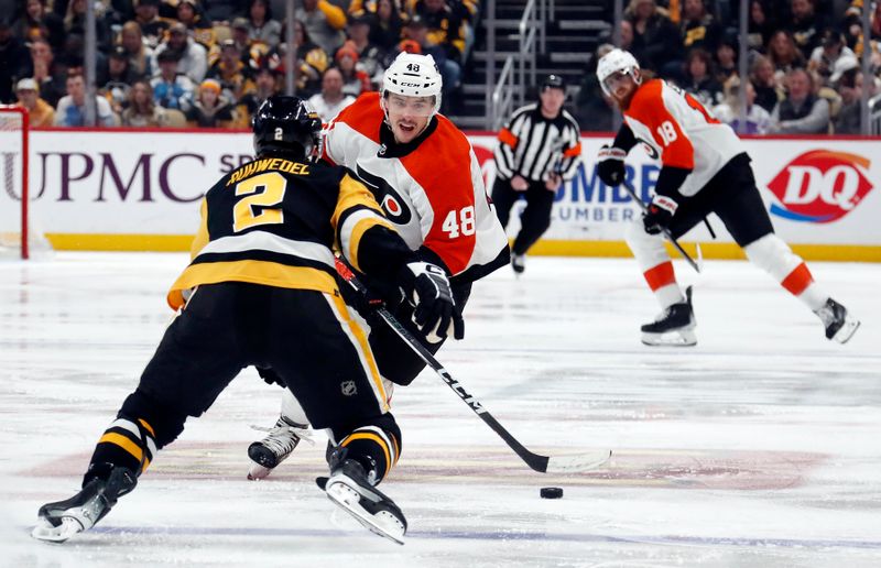 Feb 25, 2024; Pittsburgh, Pennsylvania, USA;  Philadelphia Flyers center Morgan Frost (48) skates with the puck as Pittsburgh Penguins defenseman Chad Ruhwedel (2) defends during the third period at PPG Paints Arena. Pittsburgh won 7-6. Mandatory Credit: Charles LeClaire-USA TODAY Sports