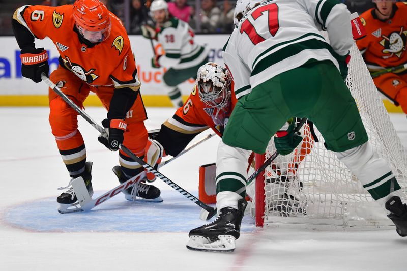 Dec 6, 2024; Anaheim, California, USA; Anaheim Ducks defenseman Brian Dumoulin (6) helps goaltender John Gibson (36) defend the goal against Minnesota Wild left wing Marcus Foligno (17) during the first period at Honda Center. Mandatory Credit: Gary A. Vasquez-Imagn Images