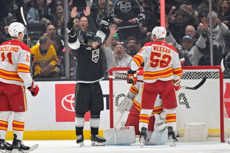 Apr 11, 2024; Los Angeles, California, USA;  Calgary Flames center Mikael Backlund (11) and defenseman MacKenzie Weegar (52) look on as Los Angeles Kings right wing Viktor Arvidsson (33) celebrates after a goal by left wing Kevin Fiala (22) in the first period at Crypto.com Arena. Mandatory Credit: Jayne Kamin-Oncea-USA TODAY Sports