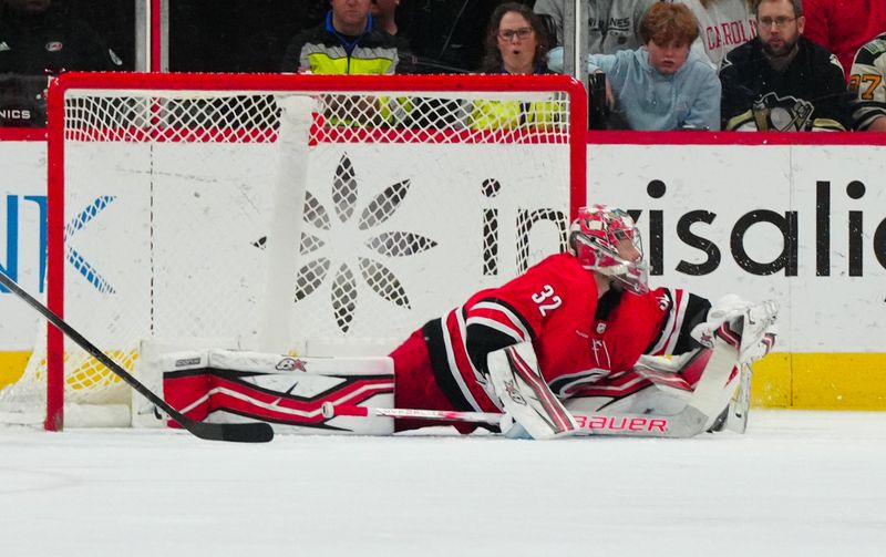 Jan 13, 2024; Raleigh, North Carolina, USA;  Carolina Hurricanes goaltender Antti Raanta (32) makes a glove save against the Pittsburgh Penguins during the third period at PNC Arena. Mandatory Credit: James Guillory-USA TODAY Sports