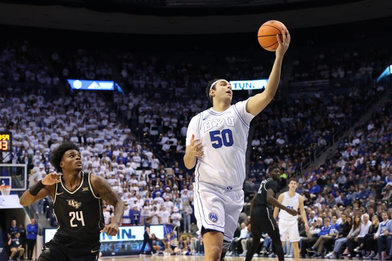 Feb 13, 2024; Provo, Utah, USA; Brigham Young Cougars center Aly Khalifa (50) handles the ball against Central Florida Knights guard Jaylin Sellers (24) during the second half at Marriott Center. Mandatory Credit: Rob Gray-USA TODAY Sports