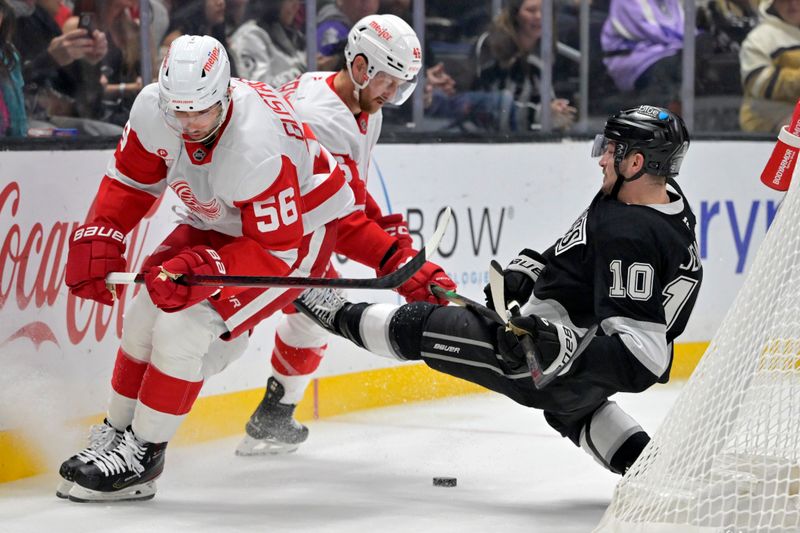 Nov 16, 2024; Los Angeles, California, USA; Los Angeles Kings left wing Tanner Jeannot (10) is checked by Detroit Red Wings defenseman Jeff Petry (46) as defenseman Erik Gustafsson (56) controls the puck in the second period at Crypto.com Arena. Mandatory Credit: Jayne Kamin-Oncea-Imagn Images