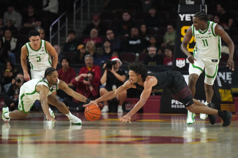 Dec 4, 2024; Los Angeles, California, USA; Southern California Trojans guard Desmond Claude (1) and Oregon Ducks guard Keeshawn Barthelemy (9) reach for the ball in the second half at Galen Center. Mandatory Credit: Kirby Lee-Imagn ImagesDec 4, 2024; Los Angeles, California, USA; at Galen Center. Mandatory Credit: Kirby Lee-Imagn Images