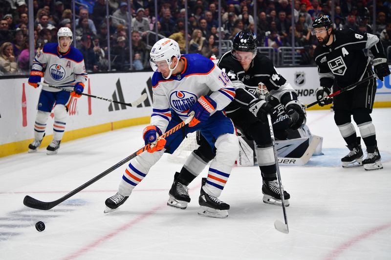 Dec 30, 2023; Los Angeles, California, USA; Los Angeles Kings defenseman Mikey Anderson (44) plays for the puck against Edmonton Oilers left wing Zach Hyman (18) during the first period at Crypto.com Arena. Mandatory Credit: Gary A. Vasquez-USA TODAY Sports