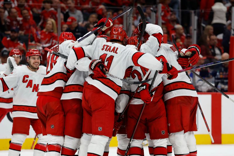 May 6, 2025; Washington, District of Columbia, USA; Carolina Hurricanes defenseman Jaccob Slavin (74) celebrates with teammates after scoring the game winning goal against the Washington Capitals in overtime in game one of the second round of the 2025 Stanley Cup Playoffs at Capital One Arena. Mandatory Credit: Geoff Burke-Imagn Images