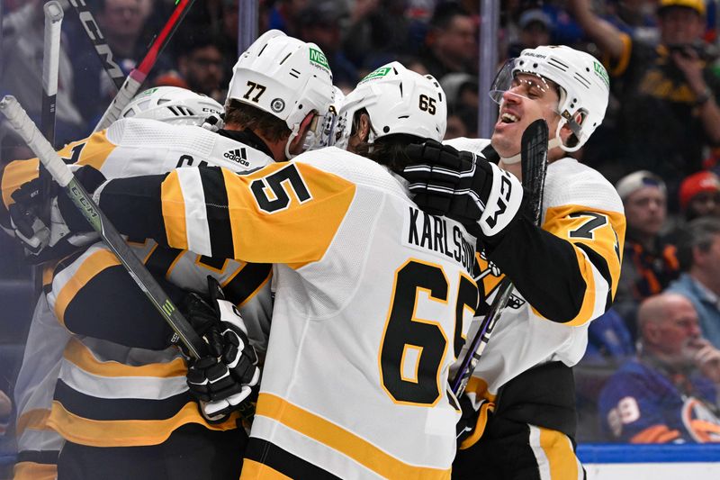 Apr 17, 2024; Elmont, New York, USA;  Pittsburgh Penguins center Evgeni Malkin (71) and defenseman Erik Karlsson (65) celebrate a goal by center Jeff Carter (77) against the New York Islanders during the third period at UBS Arena. Mandatory Credit: Dennis Schneidler-USA TODAY Sports