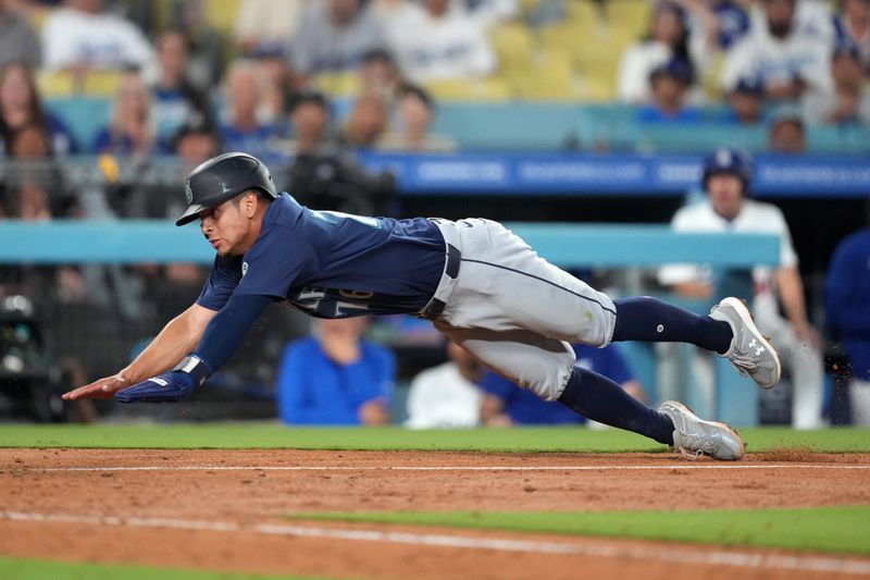 Aug 20, 2024; Los Angeles, California, USA; Seattle Mariners shortstop Leo Rivas (76) slides into home plate in the ninth inning against the Los Angeles Dodgers at Dodger Stadium. Mandatory Credit: Kirby Lee-USA TODAY Sports