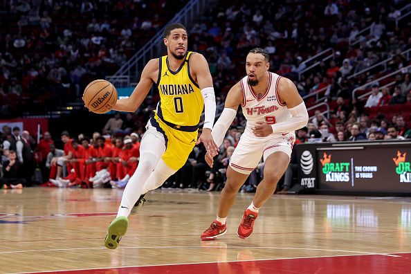 HOUSTON, TEXAS - DECEMBER 26: Tyrese Haliburton #0 of the Indiana Pacers drives to the basket in front of Dillon Brooks #9 of the Houston Rockets in the first half at Toyota Center on December 26, 2023 in Houston, Texas.  NOTE TO USER: User expressly acknowledges and agrees that, by downloading and or using this photograph, User is consenting to the terms and conditions of the Getty Images License Agreement. (Photo by Tim Warner/Getty Images)