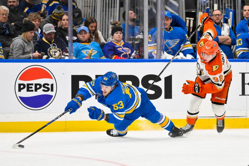 Dec 1, 2025; St. Louis, Missouri, USA; St. Louis Blues left wing Jake Neighbours (63) dives for the puck past Anaheim Ducks defenseman Pavel Mintyukov (98) during the second period at Enterprise Center. Mandatory Credit: Jeff Curry-Imagn Images