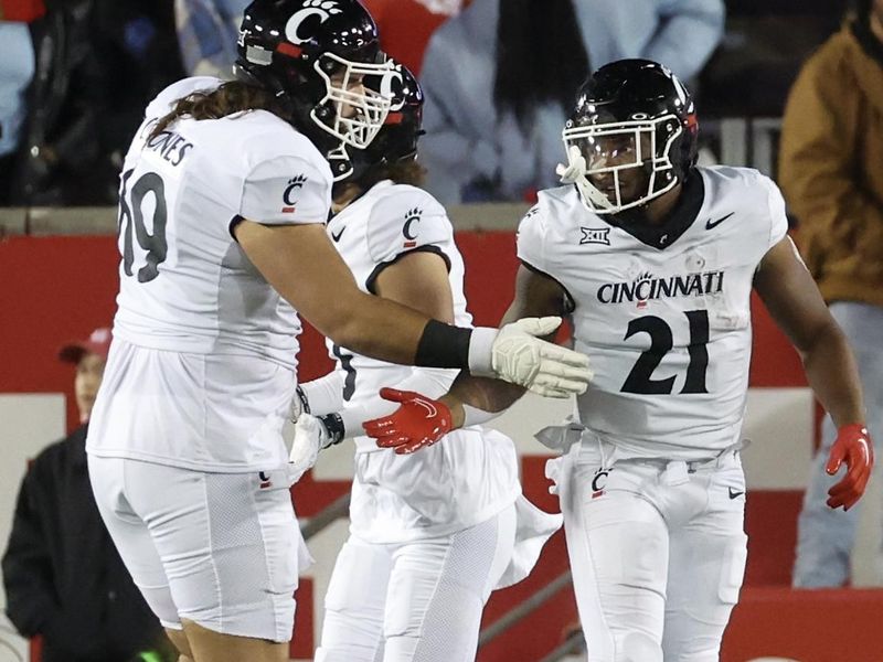 Nov 11, 2023; Houston, Texas, USA; Cincinnati Bearcats offensive lineman Cam Jones (69) celebrates running back Corey Kiner (21) rushing touchdown against the Houston Cougars in the first half at TDECU Stadium. Mandatory Credit: Thomas Shea-USA TODAY Sports