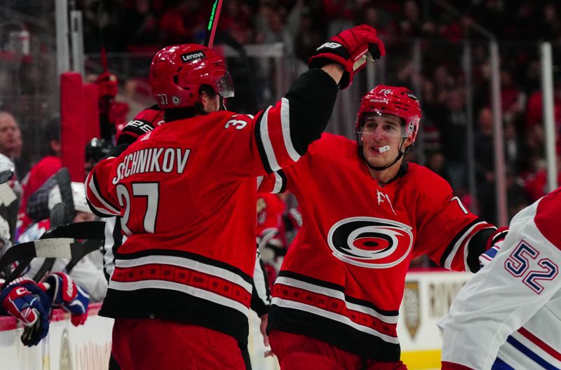 Dec 28, 2023; Raleigh, North Carolina, USA; Carolina Hurricanes right wing Andrei Svechnikov (37) celebrates his goal with defenseman Brady Skjei (76) against the Montreal Canadiens during the third period at PNC Arena. Mandatory Credit: James Guillory-USA TODAY Sports