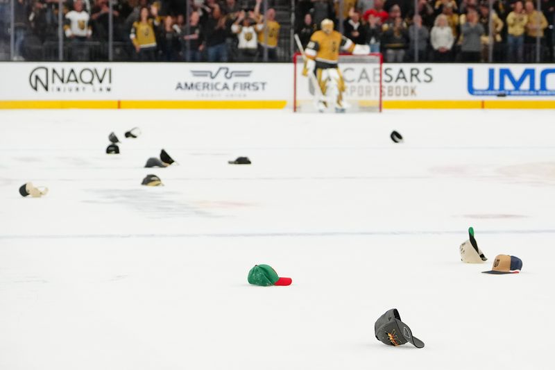 Oct 8, 2025; Las Vegas, Nevada, USA; Hats litter the ice after Vegas Golden Knights right wing Pavel Dorofeyev (16) scored his third goal against the Los Angeles Kings during the second period at T-Mobile Arena. Mandatory Credit: Stephen R. Sylvanie-Imagn Images