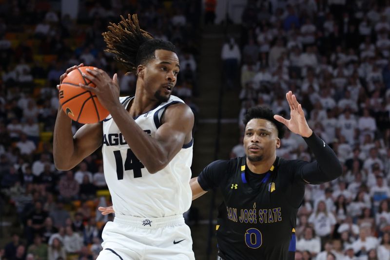 Jan 30, 2024; Logan, Utah, USA; Utah State Aggies guard Josh Uduje (14) advances the ball against San Jose State Spartans guard Myron Amey Jr. (0) during the second half at Dee Glen Smith Spectrum. Mandatory Credit: Rob Gray-USA TODAY Sports