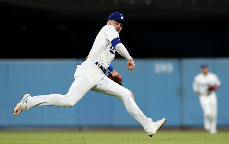 Jul 23, 2024; Los Angeles, California, USA; Los Angeles Dodgers second baseman Gavin Lux (9) chases a ground ball during the eighth inning against the San Francisco Giants at Dodger Stadium. Mandatory Credit: Jason Parkhurst-USA TODAY Sports