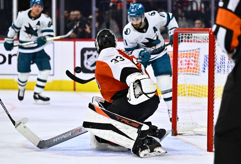 Mar 12, 2024; Philadelphia, Pennsylvania, USA; Philadelphia Flyers goalie Samuel Ersson (33) defends the net against San Jose Sharks center Luke Kunin (11) in the second period at Wells Fargo Center. Mandatory Credit: Kyle Ross-USA TODAY Sports