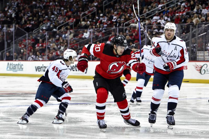 Nov 10, 2023; Newark, New Jersey, USA; New Jersey Devils center Michael McLeod (20) skates against Washington Capitals defenseman John Carlson (74) during the second period at Prudential Center. Mandatory Credit: John Jones-USA TODAY Sports