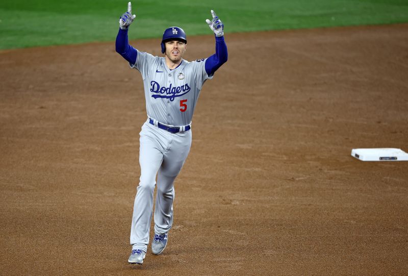 Oct 28, 2024; New York, New York, USA; Los Angeles Dodgers first baseman Freddie Freeman (5) celebrates after hitting a two-run home run during the first inning in game three of the 2024 MLB World Series against the New York Yankees at Yankee Stadium. Mandatory Credit: Vincent Carchietta-Imagn Images