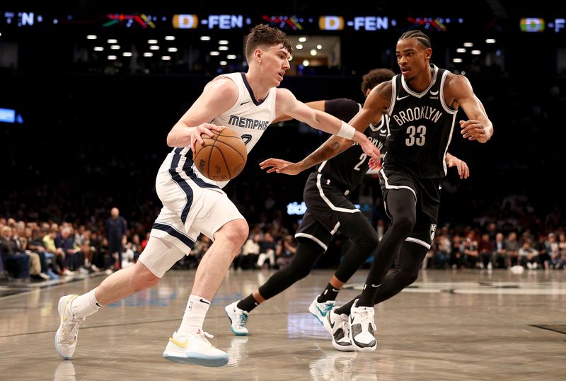 NEW YORK, NEW YORK - MARCH 04: Jake LaRavia #3 of the Memphis Grizzlies heads for the net as Nic Claxton #33 of the Brooklyn Nets defends during the first half at Barclays Center on March 04, 2024 in the Brooklyn borough of New York City. NOTE TO USER: User expressly acknowledges and agrees that, by downloading and or using this photograph, User is consenting to the terms and conditions of the Getty Images License Agreement. (Photo by Elsa/Getty Images)