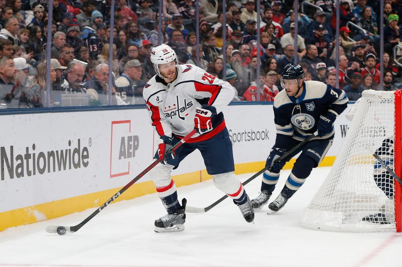 Oct 24, 2025; Columbus, Ohio, USA; Washington Capitals center Nic Dowd (26) picks up a loose puck as Columbus Blue Jackets center Charlie Coyle (3) trails the play during the first period at Nationwide Arena. Mandatory Credit: Russell LaBounty-Imagn Images