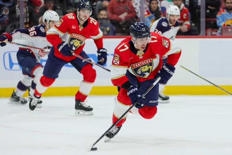 Nov 6, 2023; Sunrise, Florida, USA; Florida Panthers center Evan Rodrigues (17) moves the puck against the Columbus Blue Jackets during the first period at Amerant Bank Arena. Mandatory Credit: Sam Navarro-USA TODAY Sports