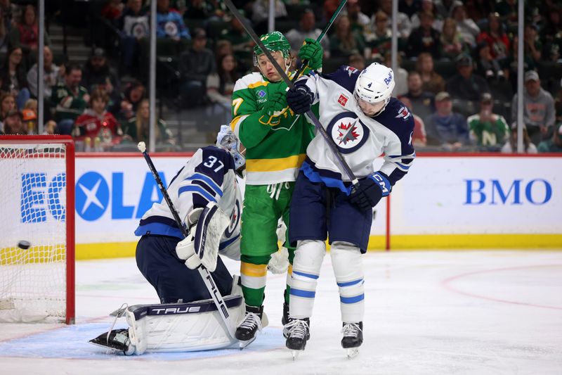 Apr 6, 2024; Saint Paul, Minnesota, USA; Winnipeg Jets defenseman Neal Pionk (4) battles Minnesota Wild left wing Kirill Kaprizov (97) during the second period at Xcel Energy Center. Mandatory Credit: Bruce Fedyck-USA TODAY Sports