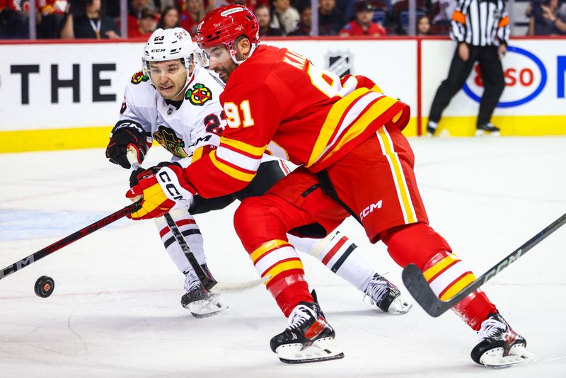 Oct 15, 2024; Calgary, Alberta, CAN; Chicago Blackhawks center Philipp Kurashev (23) and Calgary Flames center Nazem Kadri (91) battles for the puck during the first period at Scotiabank Saddledome. Mandatory Credit: Sergei Belski-Imagn Images