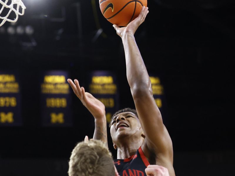 Mar 5, 2025; Ann Arbor, Michigan, USA;  Maryland Terrapins Donald Carey (0) shoots on Maryland Terrapins guard Rodney Rice (1) in the second half at Crisler Center. Mandatory Credit: Rick Osentoski-Imagn Images