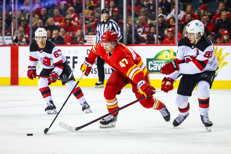 Nov 1, 2024; Calgary, Alberta, CAN; Calgary Flames center Connor Zary (47) controls the puck against New Jersey Devils center Jack Hughes (86) during the third period at Scotiabank Saddledome. Mandatory Credit: Sergei Belski-Imagn Images