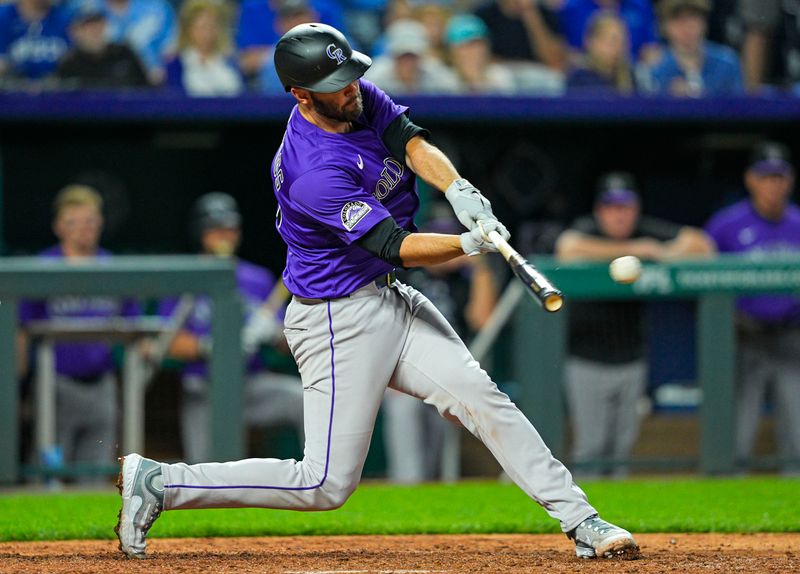 Apr 22, 2025; Kansas City, Missouri, USA; Colorado Rockies catcher Jacob Stallings (25) hits an RBI double during the ninth inning against the Kansas City Royals at Kauffman Stadium. Mandatory Credit: Jay Biggerstaff-Imagn Images
