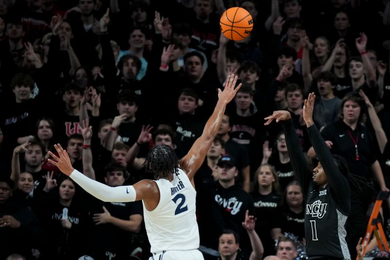 Dec 14, 2024; Cincinnati, Ohio, USA; Cincinnati Bearcats guard Day Day Thomas (1) makes a 3-point shot against Xavier Musketeers forward Jerome Hunter (2) in the first half at Fifth Third Arena. Mandatory Credit: Aaron Doster-Imagn Images