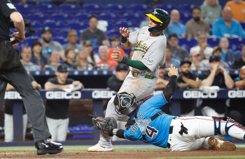 May 4, 2025; Miami, Florida, USA; Oakland Athletics third baseman Gio Urshela (13) is tagged out at the plate by Miami Marlins catcher Nick Fortes (4) during the second inning at loanDepot Park. Mandatory Credit: Rhona Wise-Imagn Images