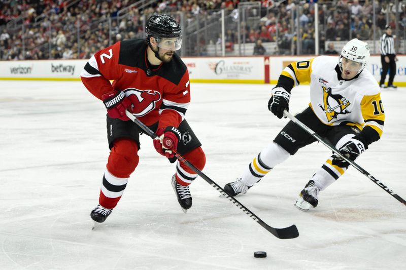 Apr 2, 2024; Newark, New Jersey, USA; New Jersey Devils defenseman Brendan Smith (2) skates with the puck while being defended by Pittsburgh Penguins left wing Drew O'Connor (10) during the second period at Prudential Center. Mandatory Credit: John Jones-USA TODAY Sports