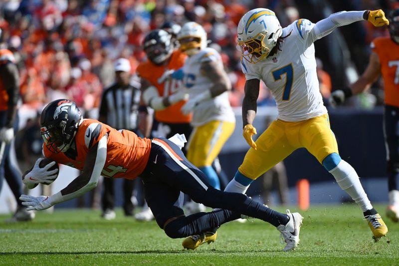 Denver Broncos wide receiver Courtland Sutton (14) catches a pass as Los Angeles Chargers cornerback Kristian Fulton (7) defends during the first half of an NFL football game, Sunday, Oct. 13, 2024, in Denver. (AP Photo/Geneva Heffernan)